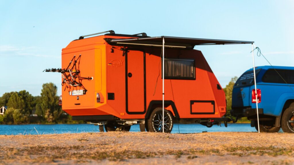 Кемпер Lifestylecamper X-Rid із розкладеною тентовою маркізою на заході сонця